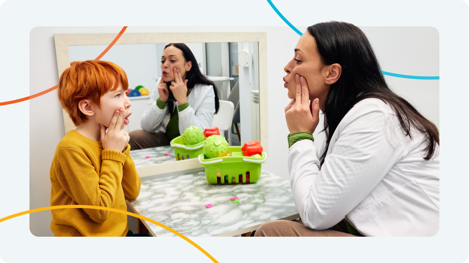 School SLP coaching a student in articulation using a mirror during speech therapy.